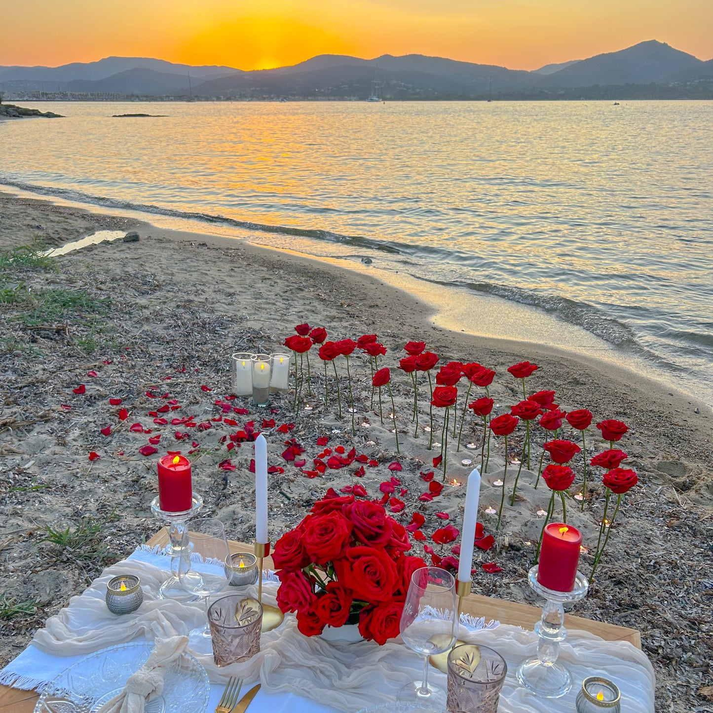 Scénographie florale : Grandes roses piquées dans le sable & bougies